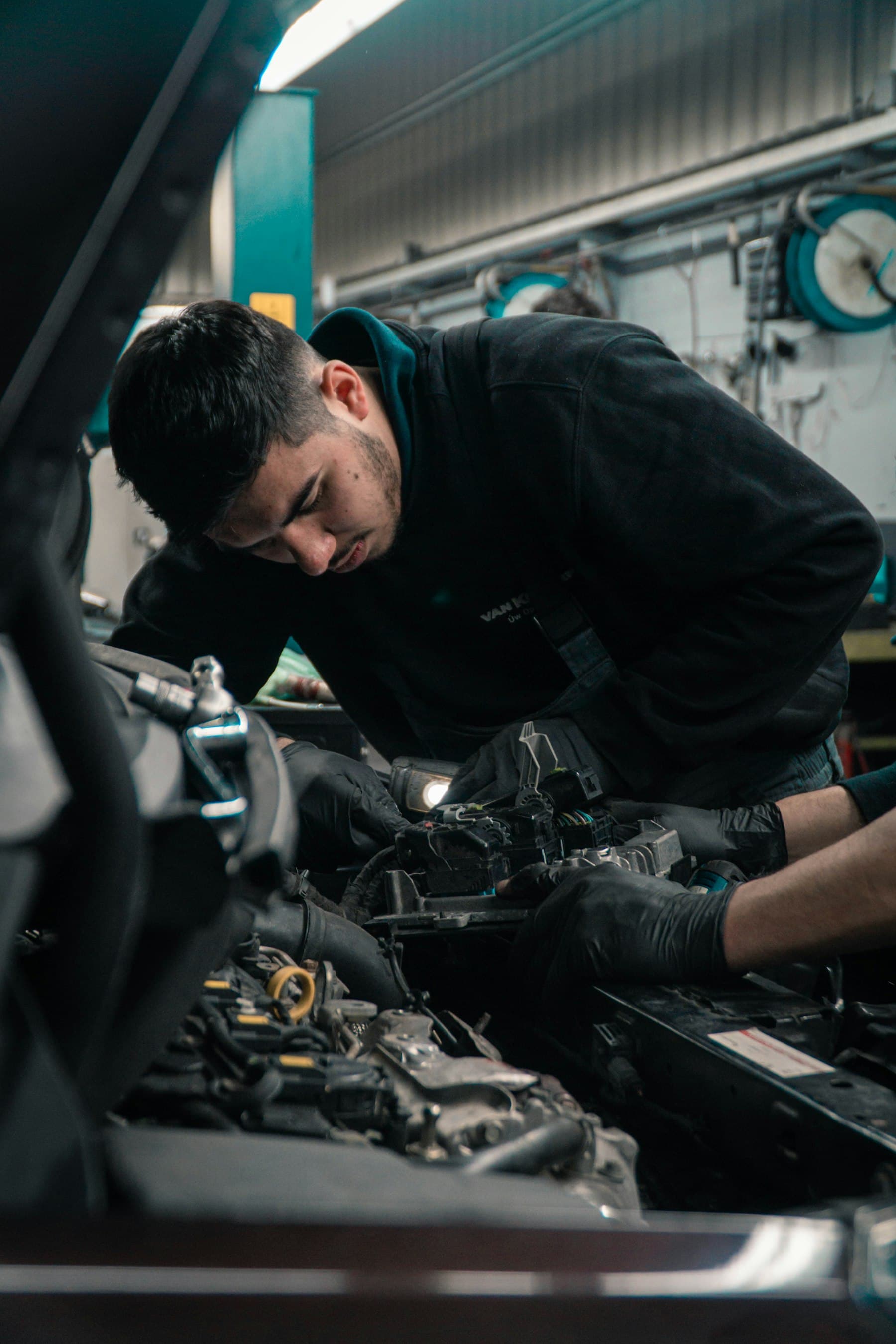 A mechanic working under the bonnet